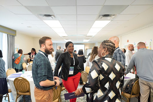 Photo of a Safety Net Innovation Lab Cohort Convening, showing government leaders sitting around a table and discussing ideas